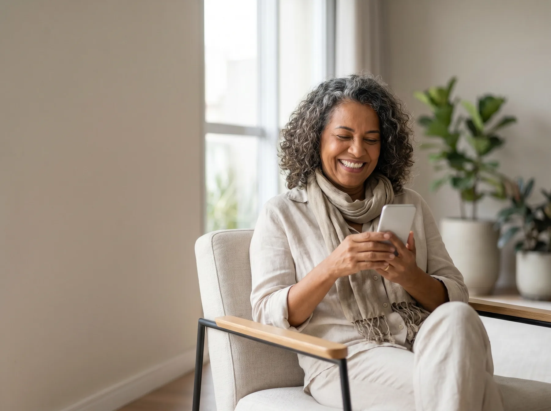Member relaxing in an armchair at home while completing the guided health intake on her phone