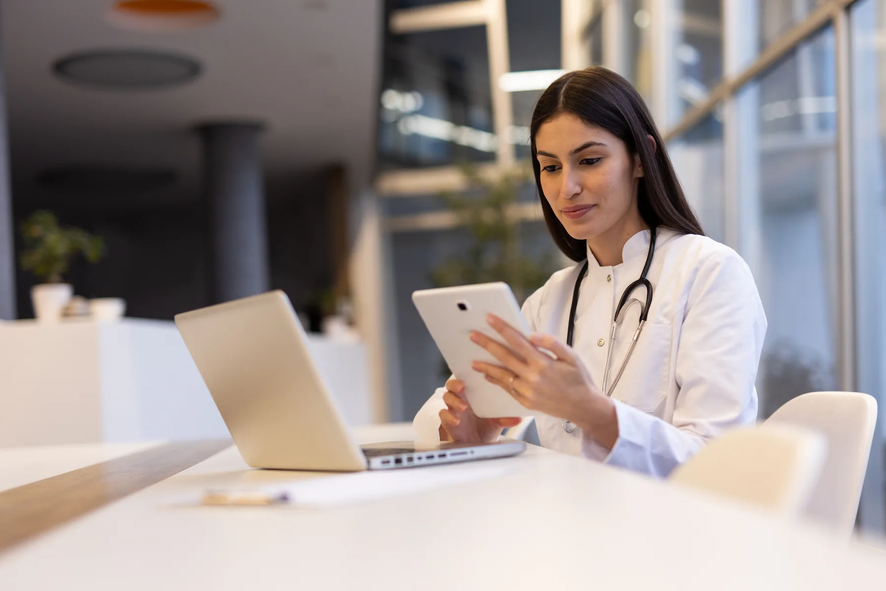 Physician reviewing patient data on a tablet in a contemporary medical office